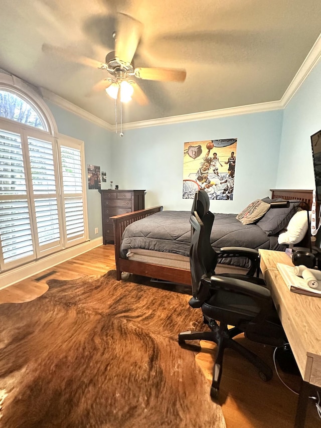 bedroom with hardwood / wood-style flooring, ceiling fan, and ornamental molding