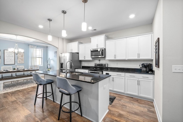 kitchen featuring white cabinetry, sink, hanging light fixtures, and appliances with stainless steel finishes