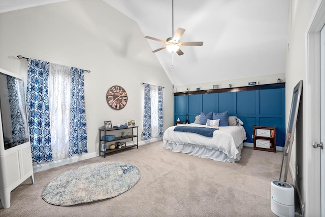 carpeted bedroom with ceiling fan and high vaulted ceiling