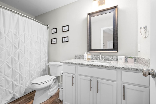 bathroom with hardwood / wood-style floors, vanity, toilet, and a shower with curtain