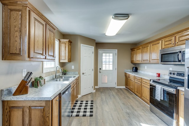 kitchen featuring sink, light hardwood / wood-style floors, and appliances with stainless steel finishes