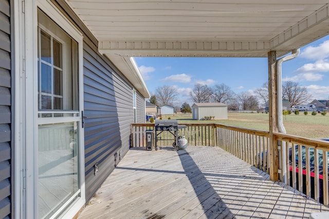 deck featuring a lawn, a grill, and a shed