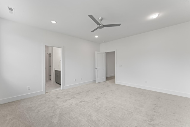 unfurnished bedroom featuring ceiling fan, ensuite bathroom, and light colored carpet