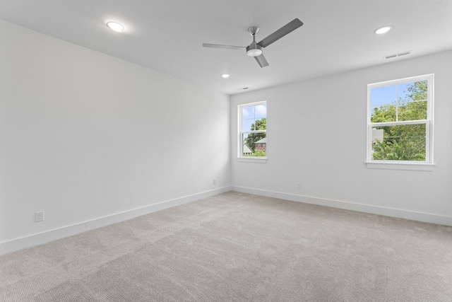 carpeted spare room with ceiling fan