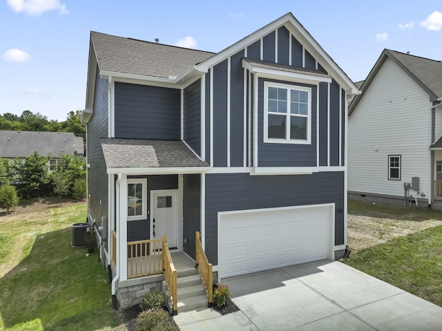 view of front of property with a garage, a front yard, and central AC unit