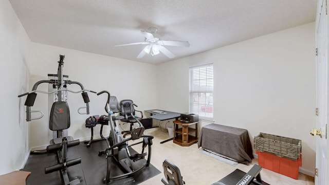 workout room featuring ceiling fan and a textured ceiling