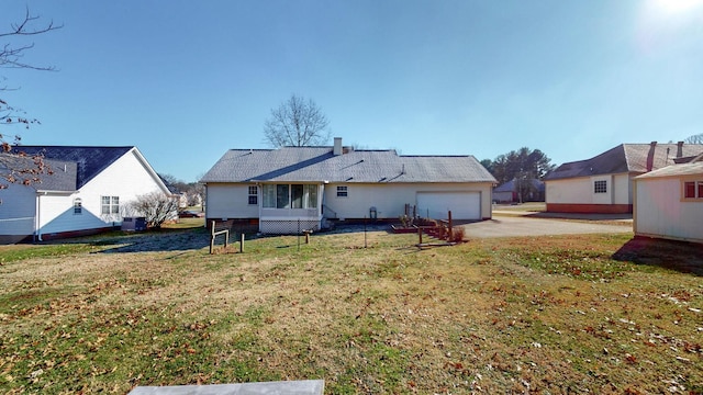 rear view of property with a yard and a garage