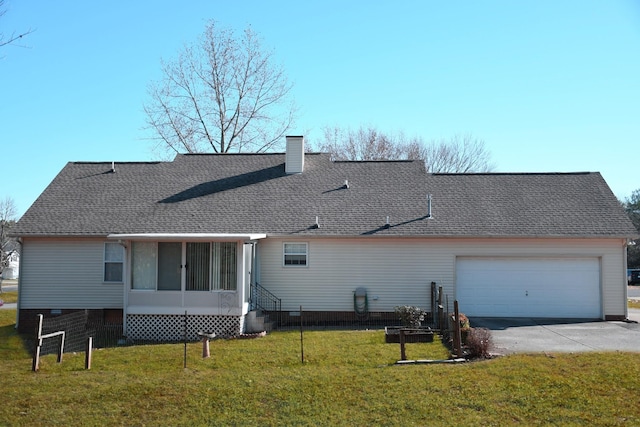 back of property with a sunroom, a yard, and a garage