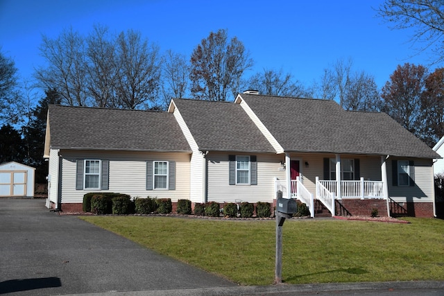 single story home featuring a front yard, a porch, and a storage unit