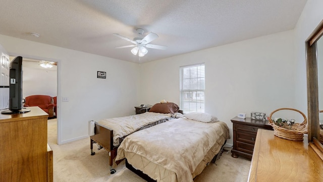 carpeted bedroom with ceiling fan and a textured ceiling