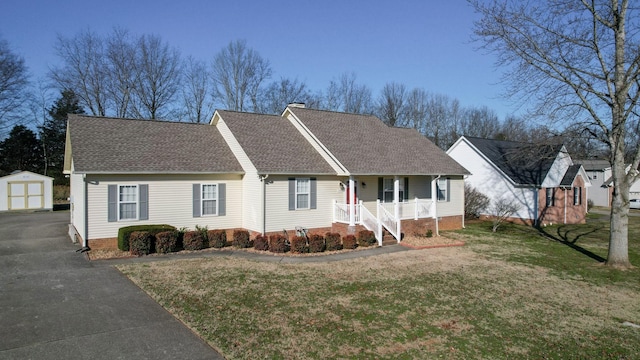 view of front of house featuring a porch, an outbuilding, and a front lawn