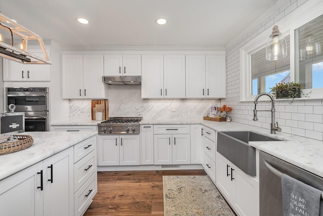 kitchen featuring white cabinets, appliances with stainless steel finishes, tasteful backsplash, and pendant lighting