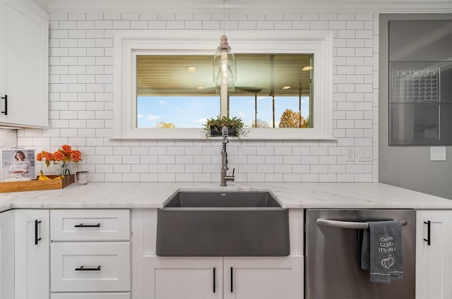 kitchen featuring backsplash, white cabinets, sink, stainless steel dishwasher, and light stone counters