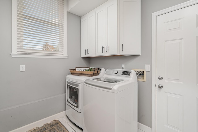 washroom featuring washing machine and clothes dryer, tile patterned floors, and cabinets