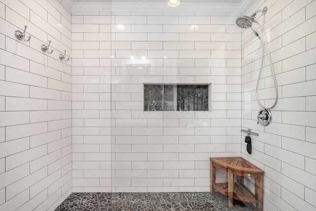 bathroom with crown molding and tiled shower