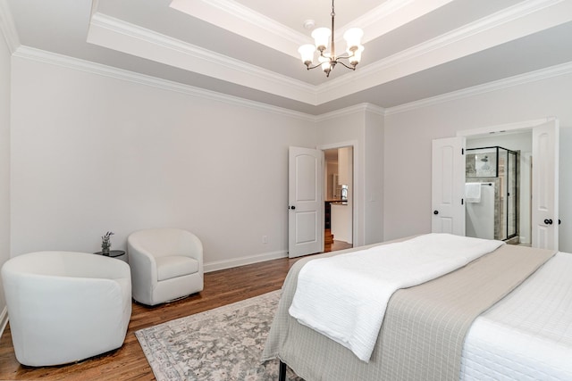 bedroom featuring wood-type flooring, a raised ceiling, ornamental molding, and a notable chandelier