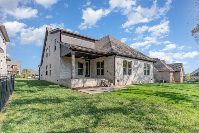 rear view of property featuring ceiling fan, a yard, and a patio