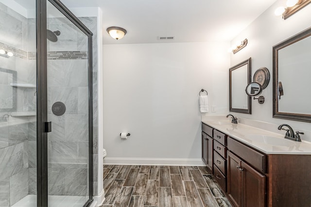 bathroom featuring vanity, toilet, and a shower with shower door