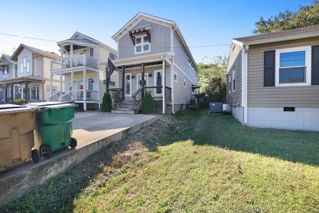 view of front of home with central air condition unit, a front lawn, and covered porch