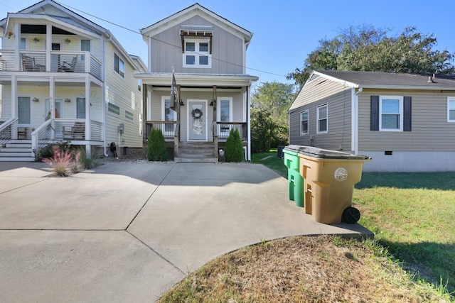 view of front of home featuring covered porch, a balcony, and a front yard