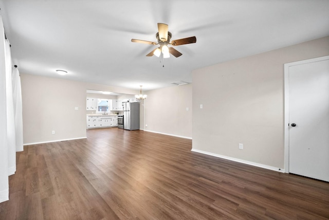 unfurnished living room with dark hardwood / wood-style flooring and ceiling fan with notable chandelier