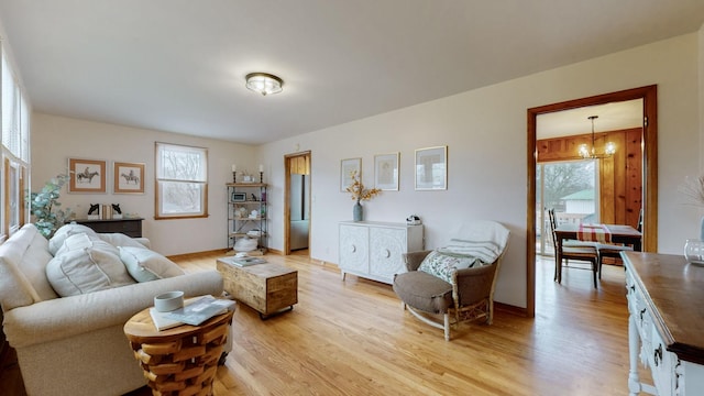 living room with light hardwood / wood-style floors and a notable chandelier