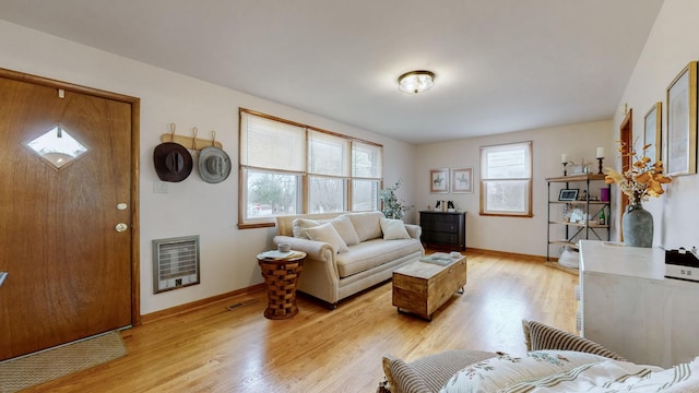 living room with heating unit and light wood-type flooring