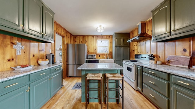 kitchen featuring stainless steel appliances, a center island, a breakfast bar area, and light wood-type flooring