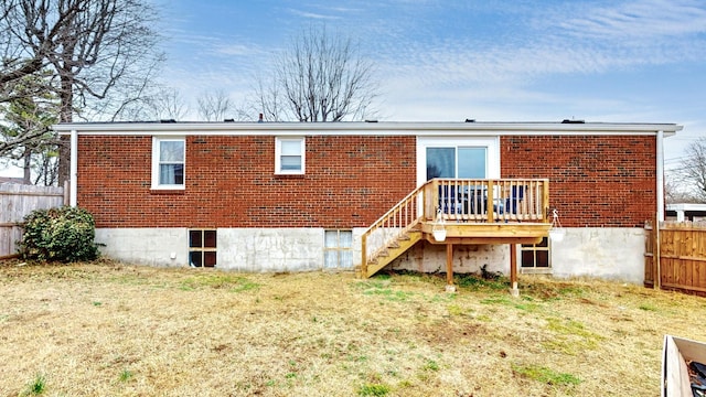 back of property featuring a wooden deck and a lawn