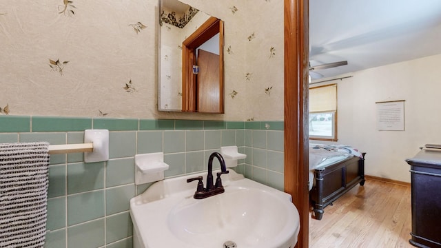 bathroom featuring wood-type flooring, sink, and tile walls