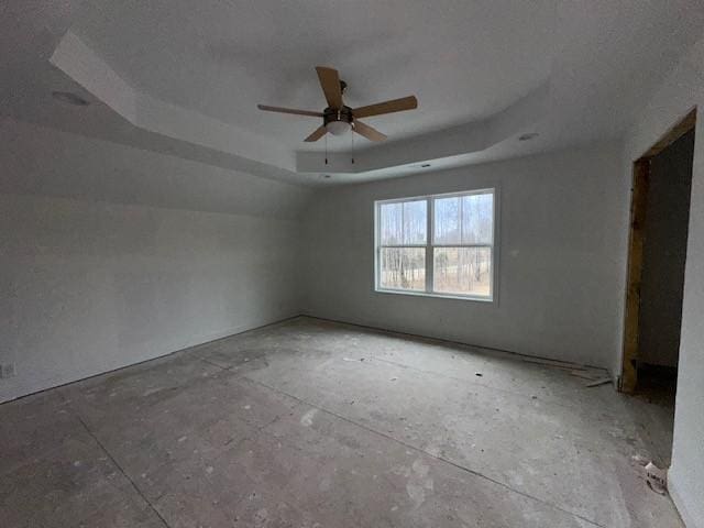 empty room featuring ceiling fan and a tray ceiling