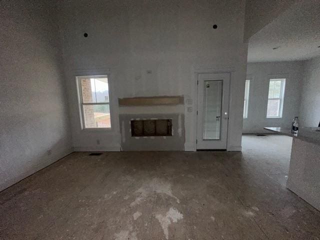 unfurnished living room with a healthy amount of sunlight, a fireplace, and visible vents