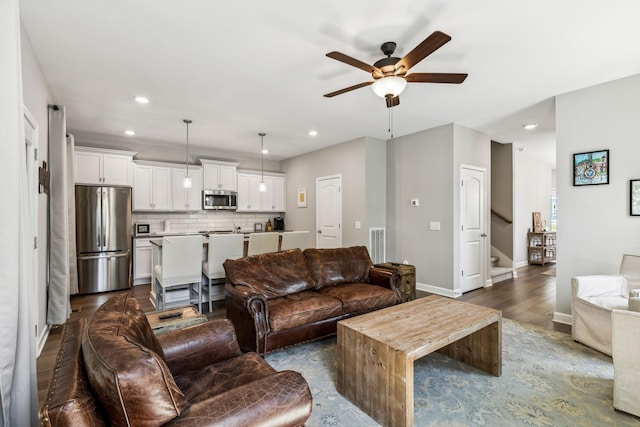 living room with ceiling fan and dark wood-type flooring