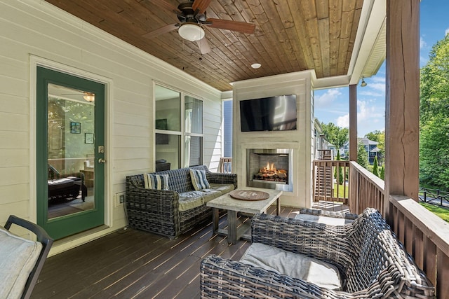 sunroom featuring ceiling fan, wooden ceiling, and an outdoor fireplace