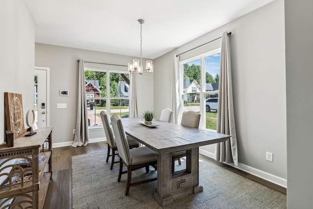 dining space featuring dark hardwood / wood-style flooring and a chandelier