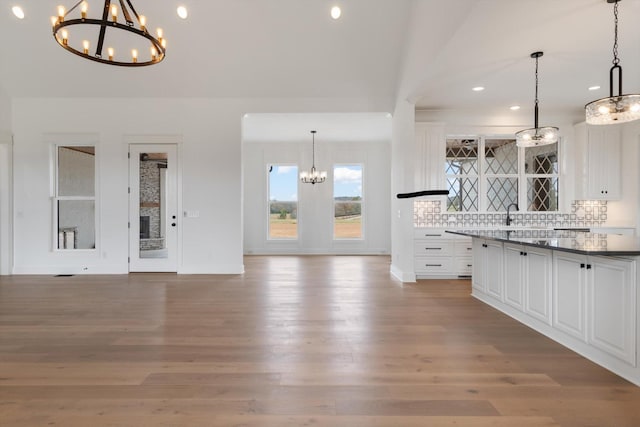 unfurnished living room with hardwood / wood-style flooring, sink, and a chandelier