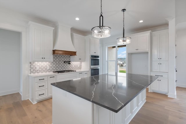 kitchen featuring custom range hood, white cabinetry, appliances with stainless steel finishes, and a large island