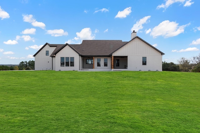 rear view of house featuring a yard and a patio