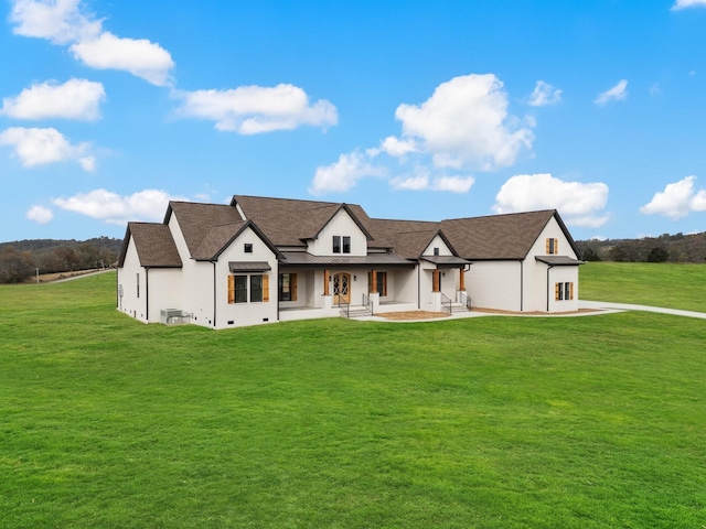 view of front of house with central AC and a front lawn