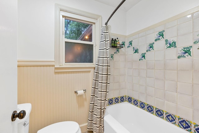 bathroom featuring shower / bath combination with curtain and toilet