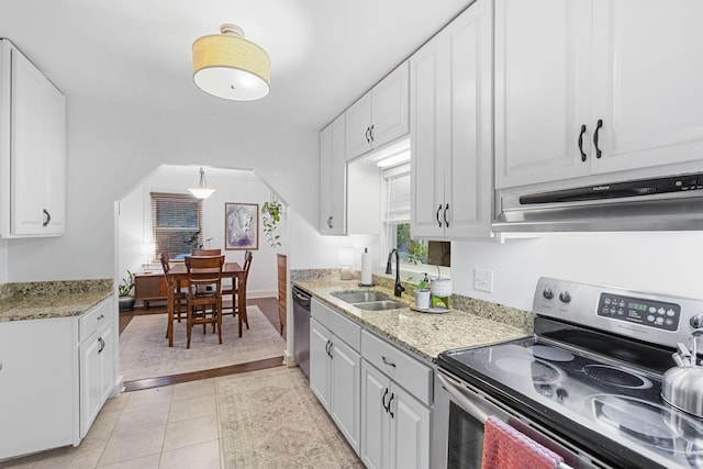 kitchen featuring white cabinets, appliances with stainless steel finishes, light stone countertops, and sink