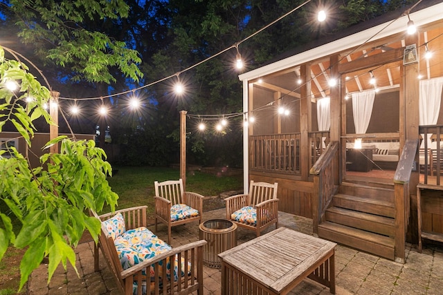 patio at night with an outdoor hangout area and a wooden deck