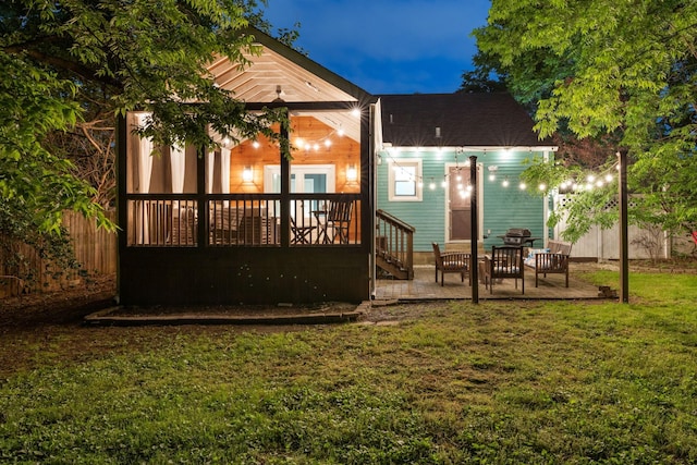 rear view of house featuring a yard and a patio