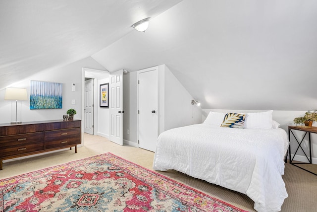 bedroom featuring light carpet and vaulted ceiling