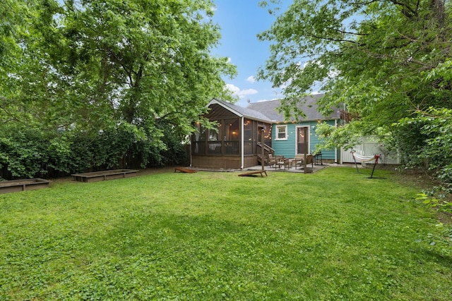 view of yard with a sunroom and a patio area