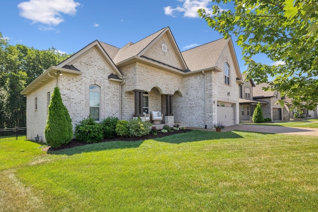 view of front facade featuring a front lawn, covered porch, and a garage