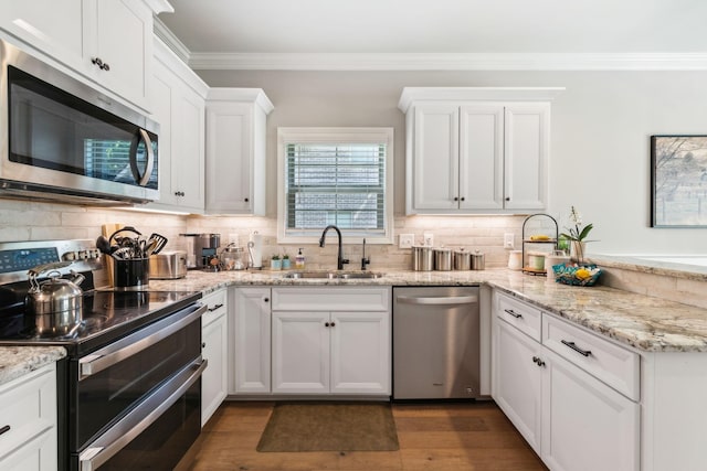 kitchen featuring white cabinets, appliances with stainless steel finishes, backsplash, and sink