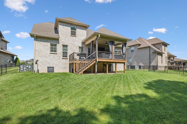 back of house featuring ceiling fan, a deck, and a yard