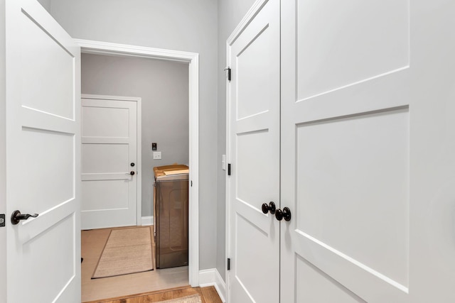 corridor featuring washer / clothes dryer and light hardwood / wood-style flooring