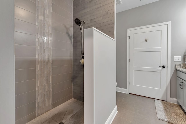 bathroom featuring tiled shower and vanity